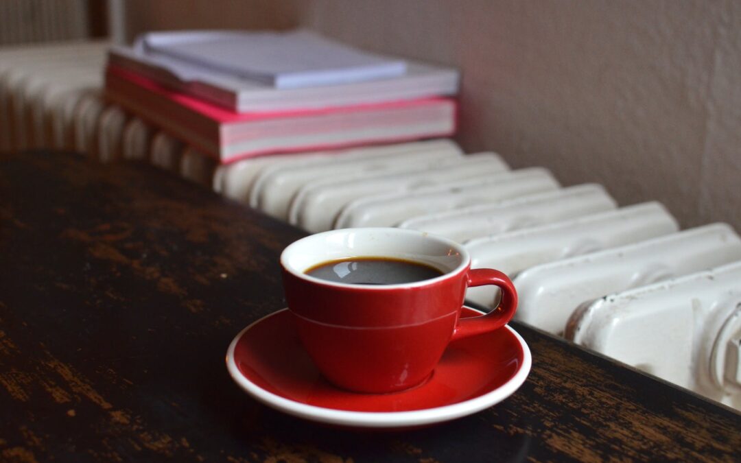 cup of coffee on table near radiator